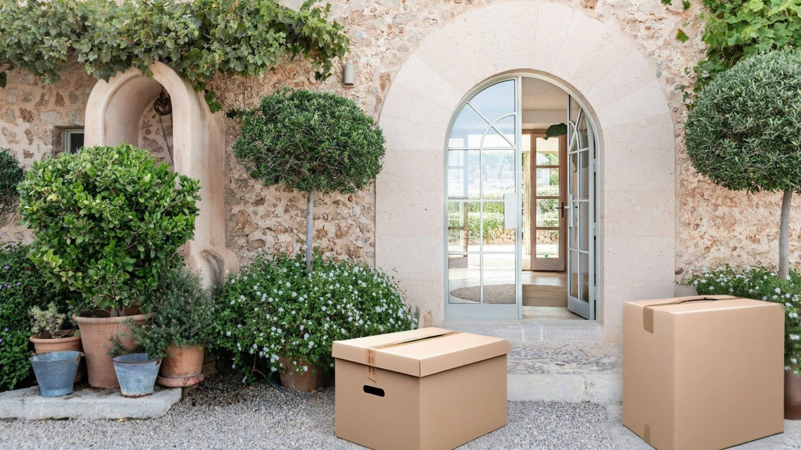 Dos cajas de mudanza frente a la puerta abierta de una villa de lujo en Mallorca - Servicio de Relocation